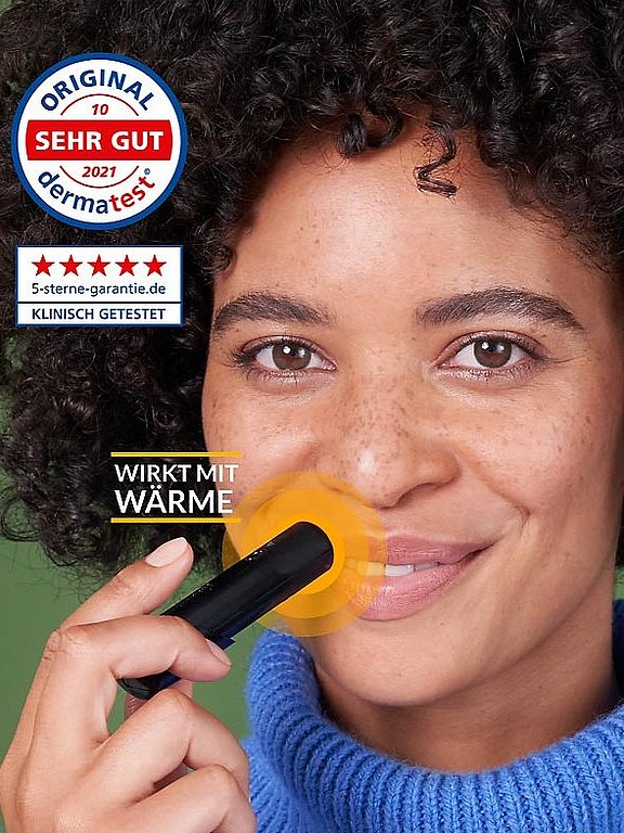 Frau nutzt den herpotherm Wärmestift bei Lippenherpes.
