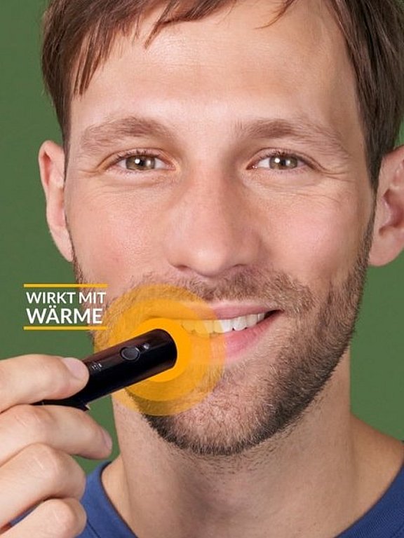 Mann nutzt den herpotherm Wärmestift bei Lippenherpes.
